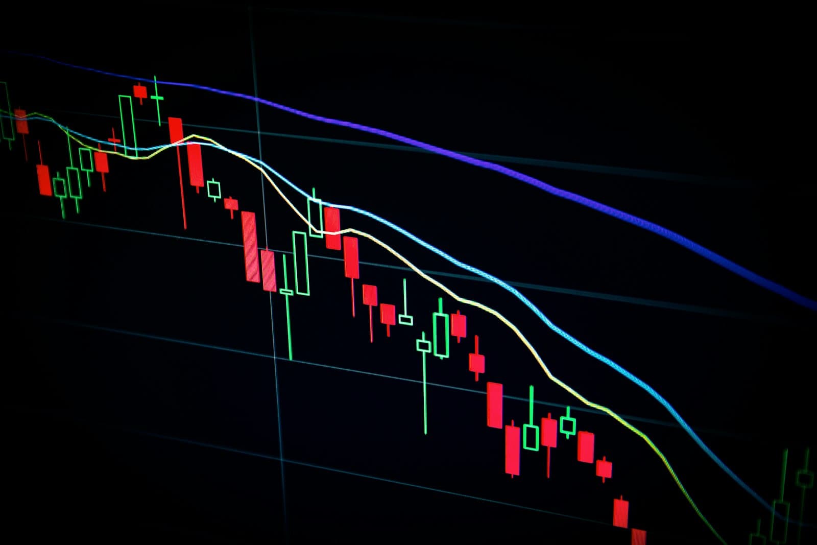Financial charts and trading interfaces on monitors.